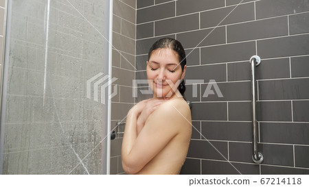 young woman hair stands under shower 67214118