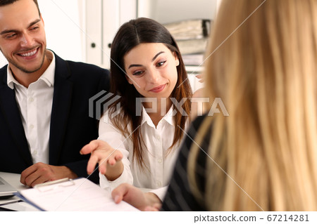 Young colleagues exploring documents at a meeting 67214281