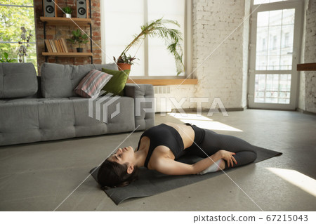 Sporty young muslim woman taking yoga lessons online and practice at home 67215043