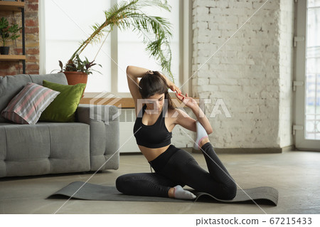 Sporty young muslim woman taking yoga lessons online and practice at home Sporty young muslim woman taking yoga lessons online and practice at home 67215433