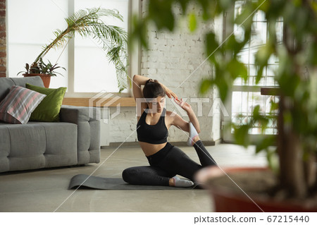 Sporty young muslim woman taking yoga lessons online and practice at home Sporty young muslim woman taking yoga lessons online and practice at home 67215440