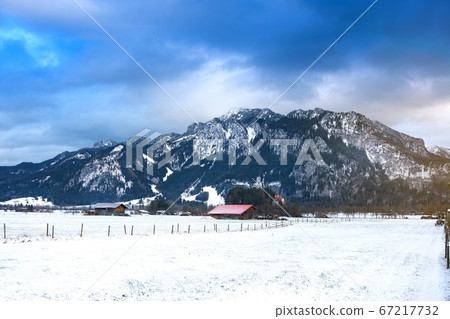 Wooden shed in snowy field against Alps in winter Wooden shed in snowy field against Alps in winter 67217732