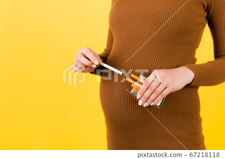 Close up of pregnant woman in brown dress taking a Close up of pregnant woman in brown dress taking a 67218118