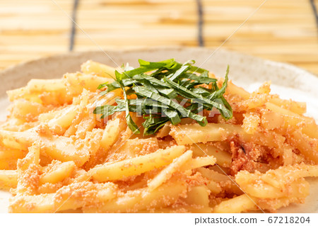 Stir-fried potatoes and mentaiko mentaiko (with large leaves). Background, blinds. 67218204