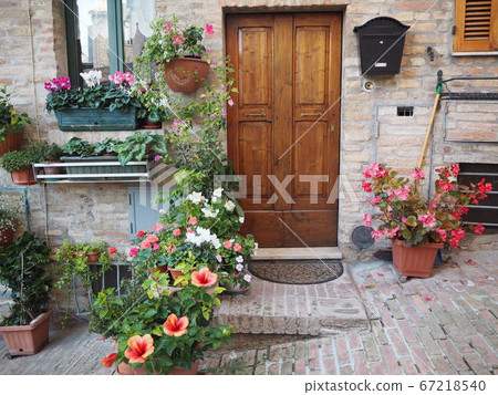 The front door of the old town house surrounded by bright flowers 67218540