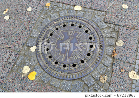 Street manhole cover on the paving stones in Berlin Street manhole cover on the paving stones in Berlin 67218965
