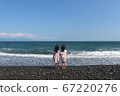 Twin girls staring at the sea Twin girls staring at the sea 67220276