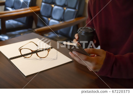 A man using his smartphone in a stylish winter cafe A man using his smartphone in a stylish winter cafe 67220373