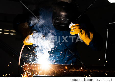 Metal welder working with arc welding machine. Metal welder working with arc welding machine. 67220991