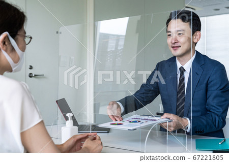 Businessman talking through acrylic partition Infection control social distance Businessman talking through acrylic partition Infection control social distance 67221805