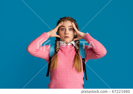 Shocked teenager girl presses hands to face Shocked teenager girl presses hands to face 67221980