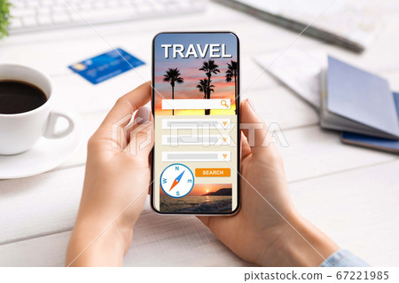 Woman using modern smartphone with travel booking website on screen 67221985