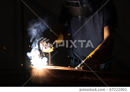 Metal welder working with arc welding machine. Metal welder working with arc welding machine. 67222001