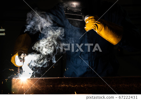 Metal welder working with arc welding machine. Metal welder working with arc welding machine. 67222431