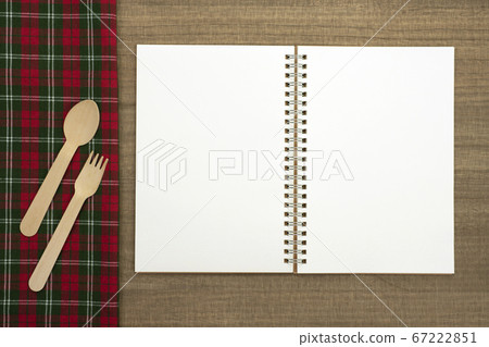 Napkins with sketchbook and spoon and fork on wood table 67222851