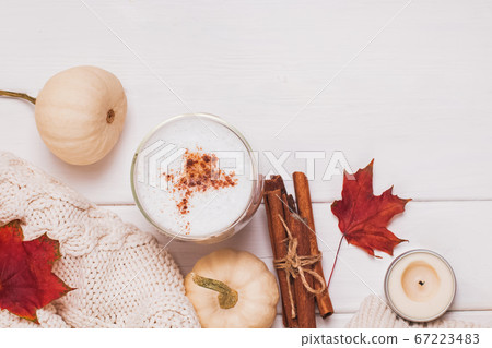 Cup of coffee with milk and cinnamon, autumn leaves and pumpkins 67223483