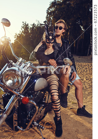Sexy couple of bikers on the vintage custom motorcycle, girl in a rabbit mask Sexy couple of bikers on the vintage custom motorcycle, girl in a rabbit mask 67223573
