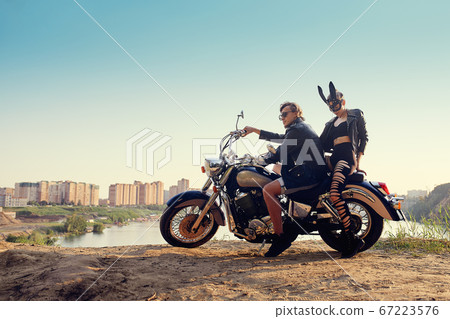 Sexy couple of bikers on the vintage custom motorcycle, girl in a rabbit mask 67223576