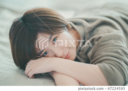 看在床上的睡衣的婦女照相機 看在床上的睡衣的婦女照相機 67224593