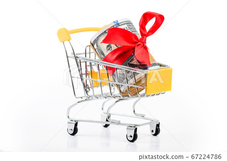roll of dollars bill banknotes with red ribbon in supermarket trolley cart consumer basket as unconditional income or gift 67224786