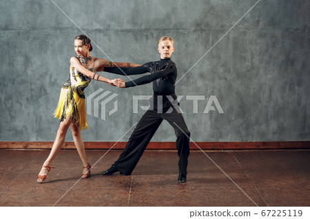 Young couple sport dancers dancing in ballroom dance cha-cha-cha. 67225119