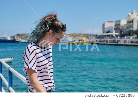 Traveling teenager girl on sea bay enjoys beauty nature, summer holidays on sea voyage Traveling teenager girl on sea bay enjoys beauty nature, summer holidays on sea voyage 67225896