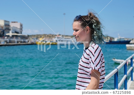 Traveling teenager girl on sea bay enjoys beauty nature, summer holidays on sea voyage Traveling teenager girl on sea bay enjoys beauty nature, summer holidays on sea voyage 67225898