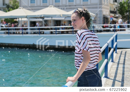 Traveling teenager girl on sea bay enjoys beauty nature, summer holidays on sea voyage 67225902