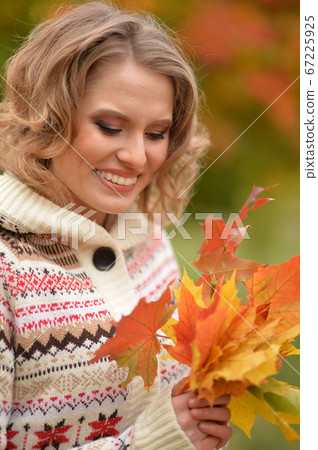 Portrait of young woman resting in park Portrait of young woman resting in park 67225925