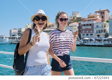 Happy mother and daughter with ice-cream on sunny day near sea promenade Happy mother and daughter with ice-cream on sunny day near sea promenade 67225943