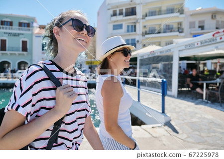 Walking happy mother parent and teenage daughter summer holidays together 67225978
