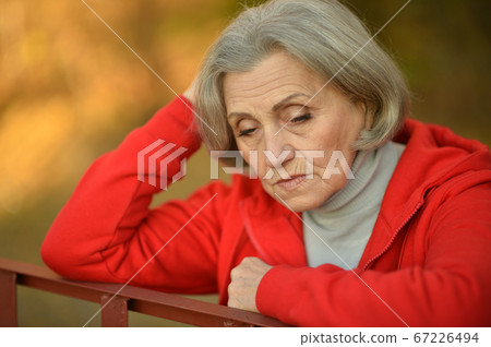 Portrait of sad senior woman in park Portrait of sad senior woman in park 67226494