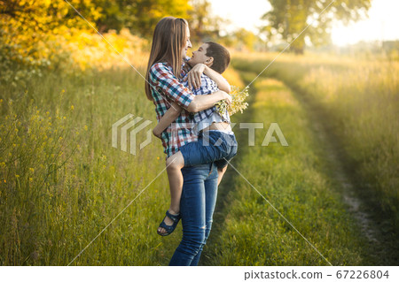 happy mom and son are playing on a summer green meadow 67226804