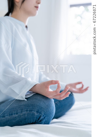 Young woman meditating at home Young woman meditating at home 67226871