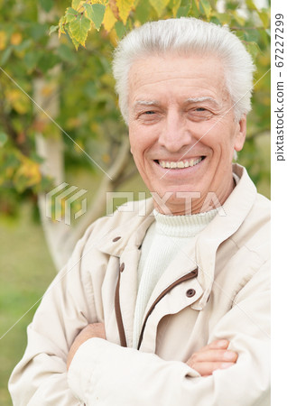 Portrait of happy smiling senior man in park Portrait of happy smiling senior man in park 67227299