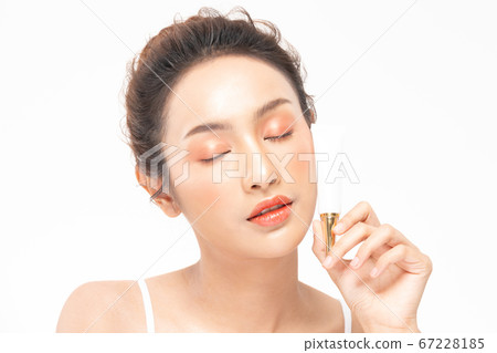 Beautiful Young Asian Woman Holding luxury white clean tube smile feeling so happy and cheerful with healthy Clean and Fresh skin,isolated on gray background,Beauty Cosmetics spa and treatment Concept 67228185