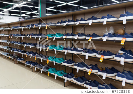 many shoes on the shelves are in the shoe store 67228358