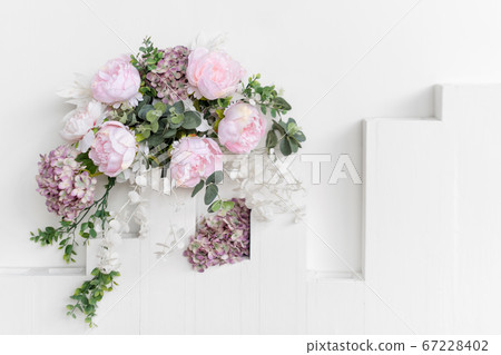 Flower wall, wedding backdrop, floral hand made decoration. Light background of artifical flowers. Vertical garden with peonies and hydrangeas. Elegant arrangement floristics setting. Copyspace. 67228402