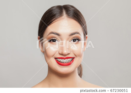 Happy girl with braces on teeth on white, 67230051