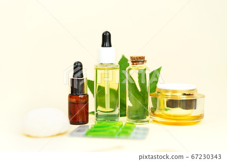 Glass bottles with herbal CBD oil, tincture, pills and hemp leaf on beige. Glass bottles with herbal CBD oil, tincture, pills and hemp leaf on beige. 67230343