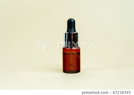 Glass bottles with herbal CBD oil, THC tincture on pastel beige background. 67230345