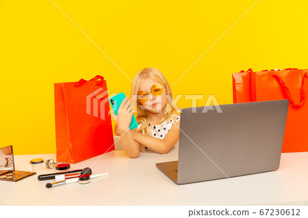 Cute girl blogger recording video and showing her purchase to followers. Cute girl blogger recording video and showing her purchase to followers. 67230612