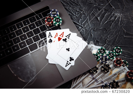 Poker cards and stacks of poker chips on a laptop computer. Poker online concept Poker cards and stacks of poker chips on a laptop computer. Poker online concept 67230820