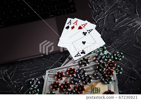 Online poker casino theme. Gambling chips and playing cards on grey background Online poker casino theme. Gambling chips and playing cards on grey background 67230821