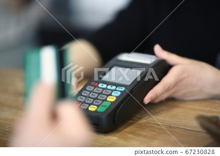 Client using credit card to pay in a cafe Client using credit card to pay in a cafe 67230828