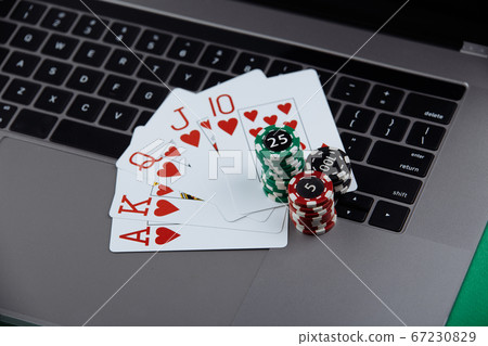 Stacks of poker chips and playing cards on a laptop computer. Casino and poker online concept Stacks of poker chips and playing cards on a laptop computer. Casino and poker online concept 67230829