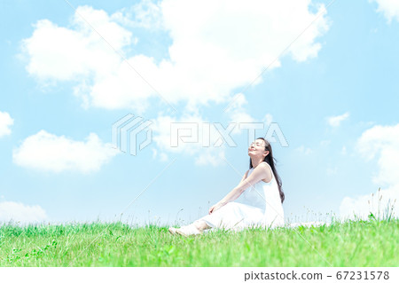 Young woman against the blue sky Young woman against the blue sky 67231578