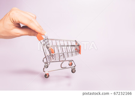 hand holding empty metal shopping basket. Concept of consumerism, shopping symbol. Copy space trend 67232166