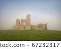 Old castle ruins in a dense fog 67232317