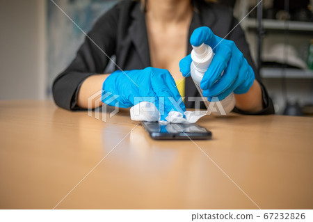 Woman's hand in blue gloves sanitizing cleaning 67232826